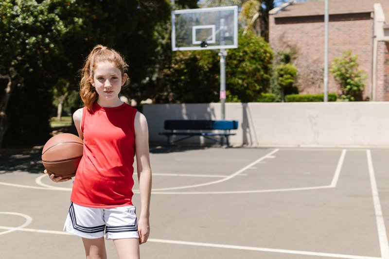 Child holding a basketball outdoors